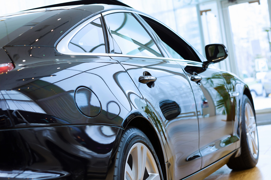Rear side view of black luxury sedan inside car showroom at Steve Kouli Smash Repairs