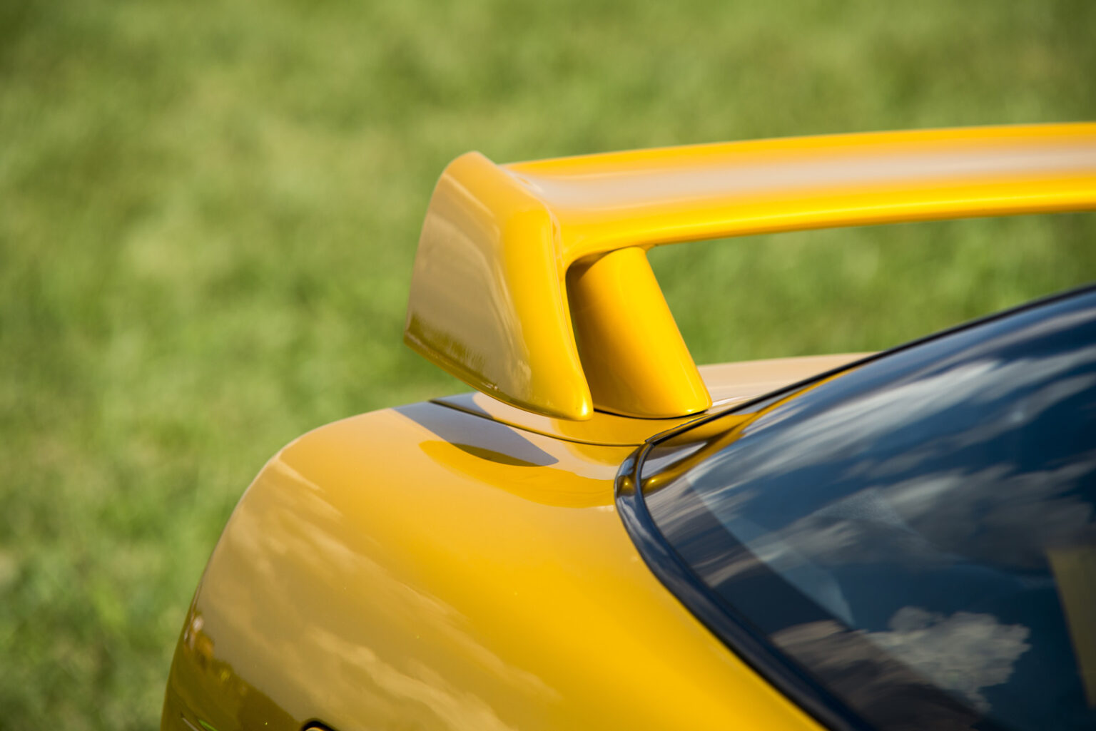 Close-up of yellow custom racing spoiler on sports car at Steve Kouli Smash Repairs