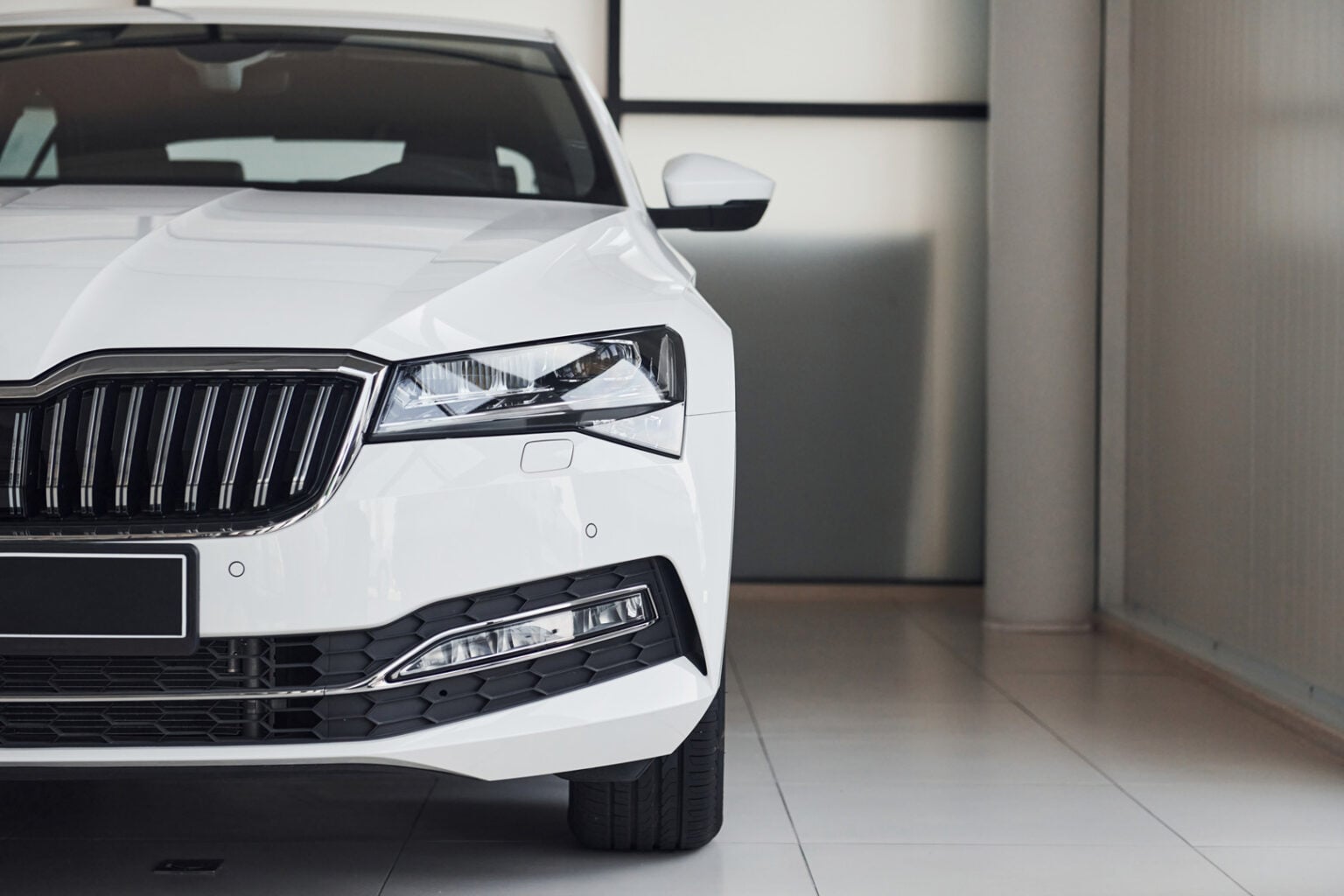 Front view of modern white car in Steve Koulis Smash Repairs showroom